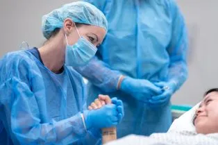 Anesthesiologist holding patients hand