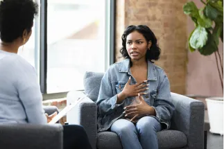Young female patient talking to a mental health professional.