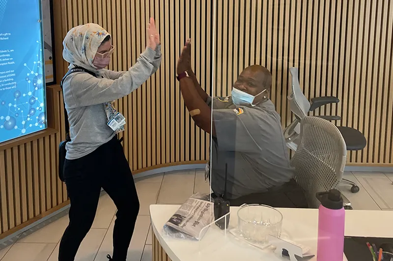 student air-fiving with security guard