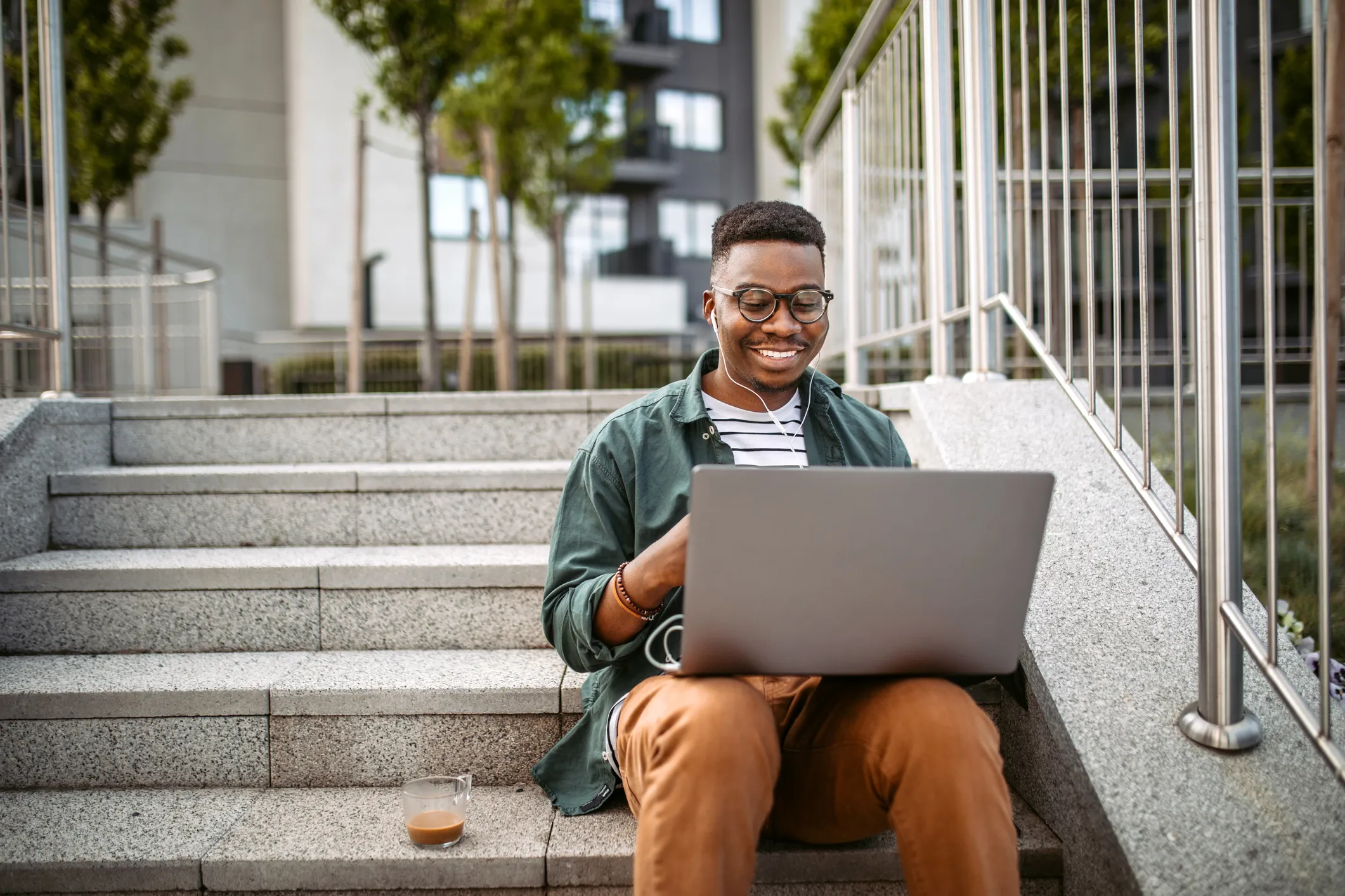 Man sitting on stairs using a laptop