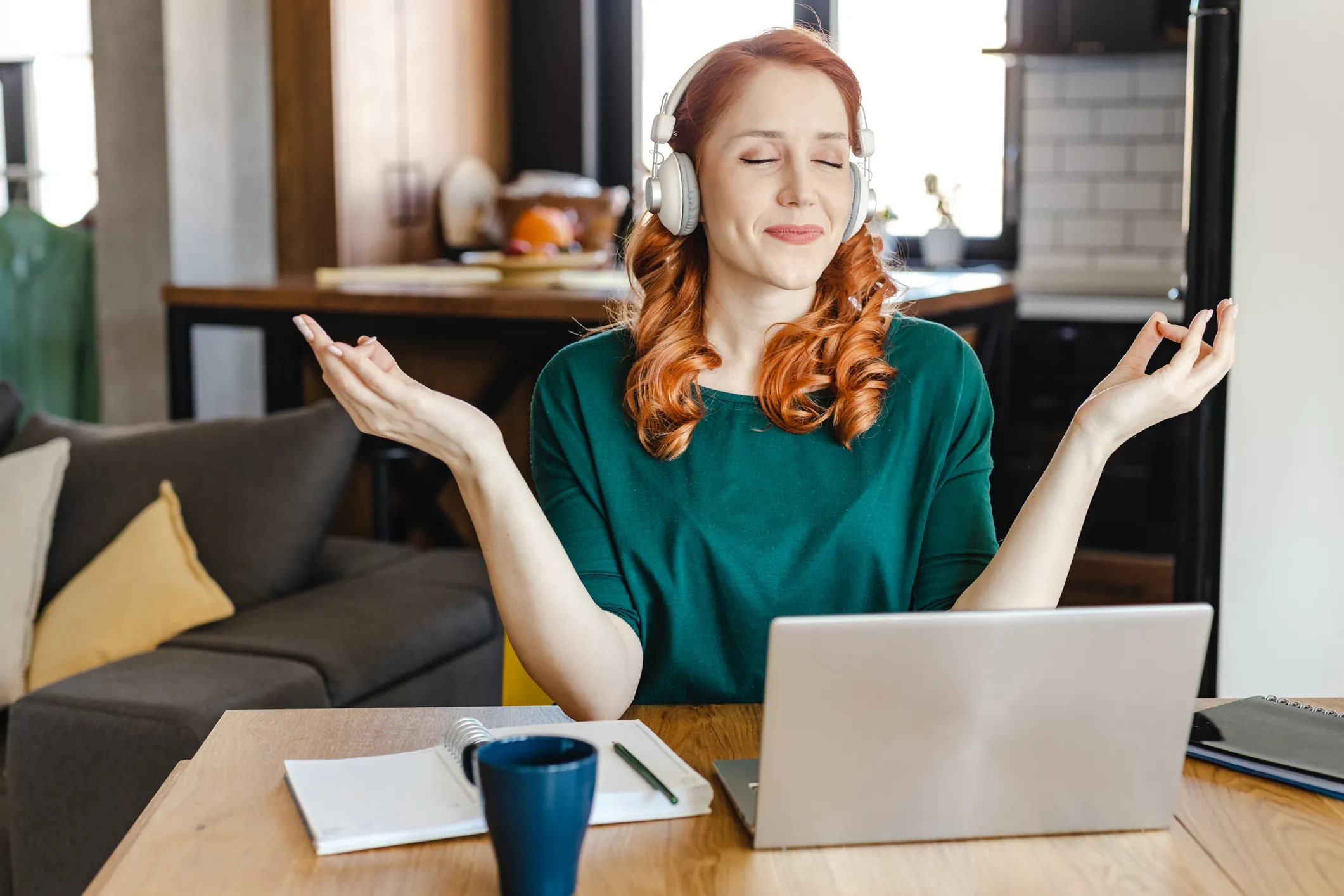 Woman meditating in front of a laptop