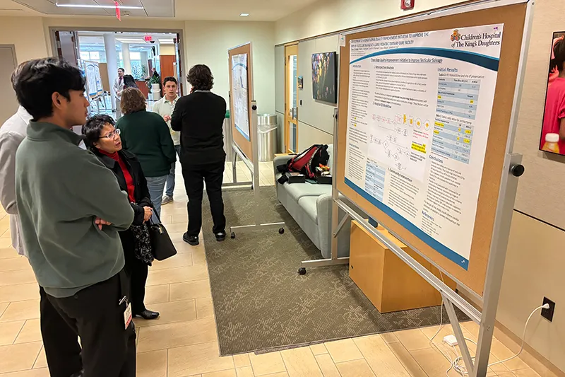 students sharing their research posters in a hallway.