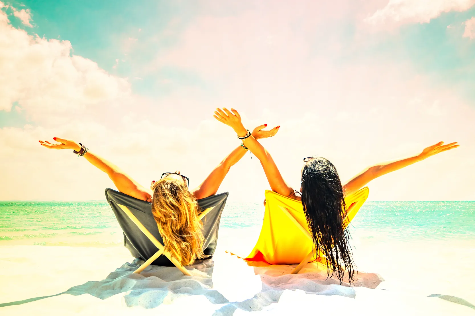 girls laying in the sun on the beach.
