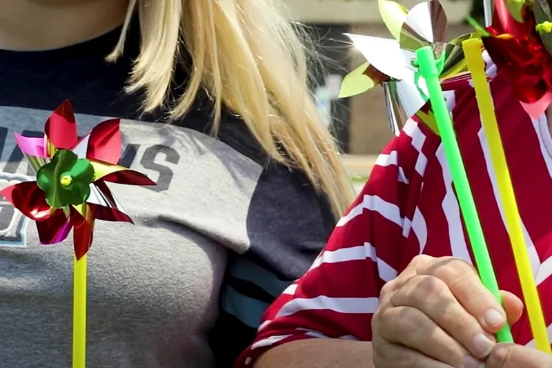 Two people holding pinwheels at Remembrance ceremony