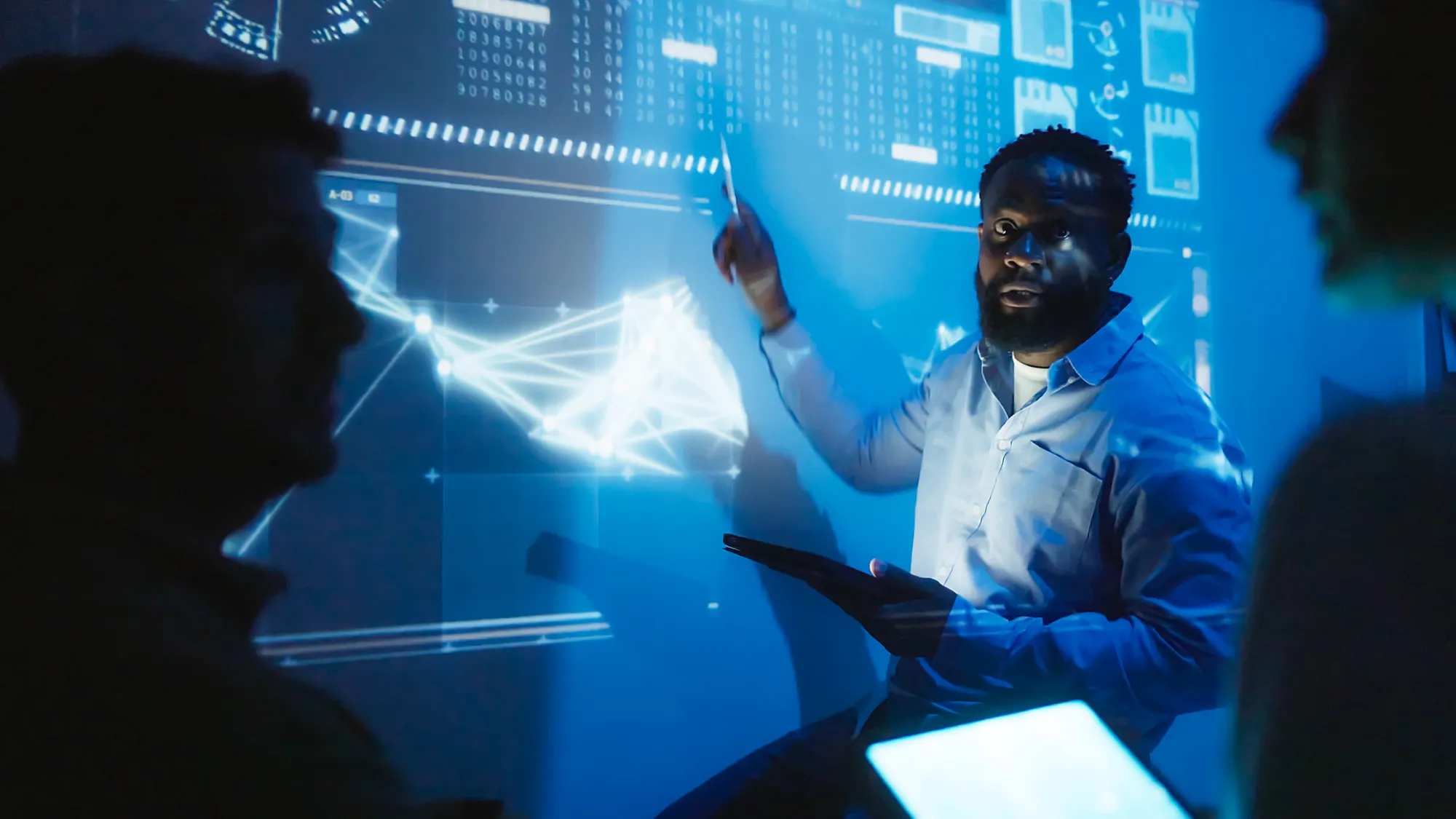 Man in front of projected chart explaining to other scientists