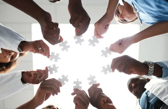 Medical Professionals holding puzzle pieces in a circle