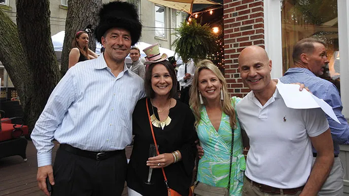 A group of four people in hats pose for a photo together. An Alice in Wonderland “Mad Hatter” party to benefit EVMS was a wonderful event held in Ghent.