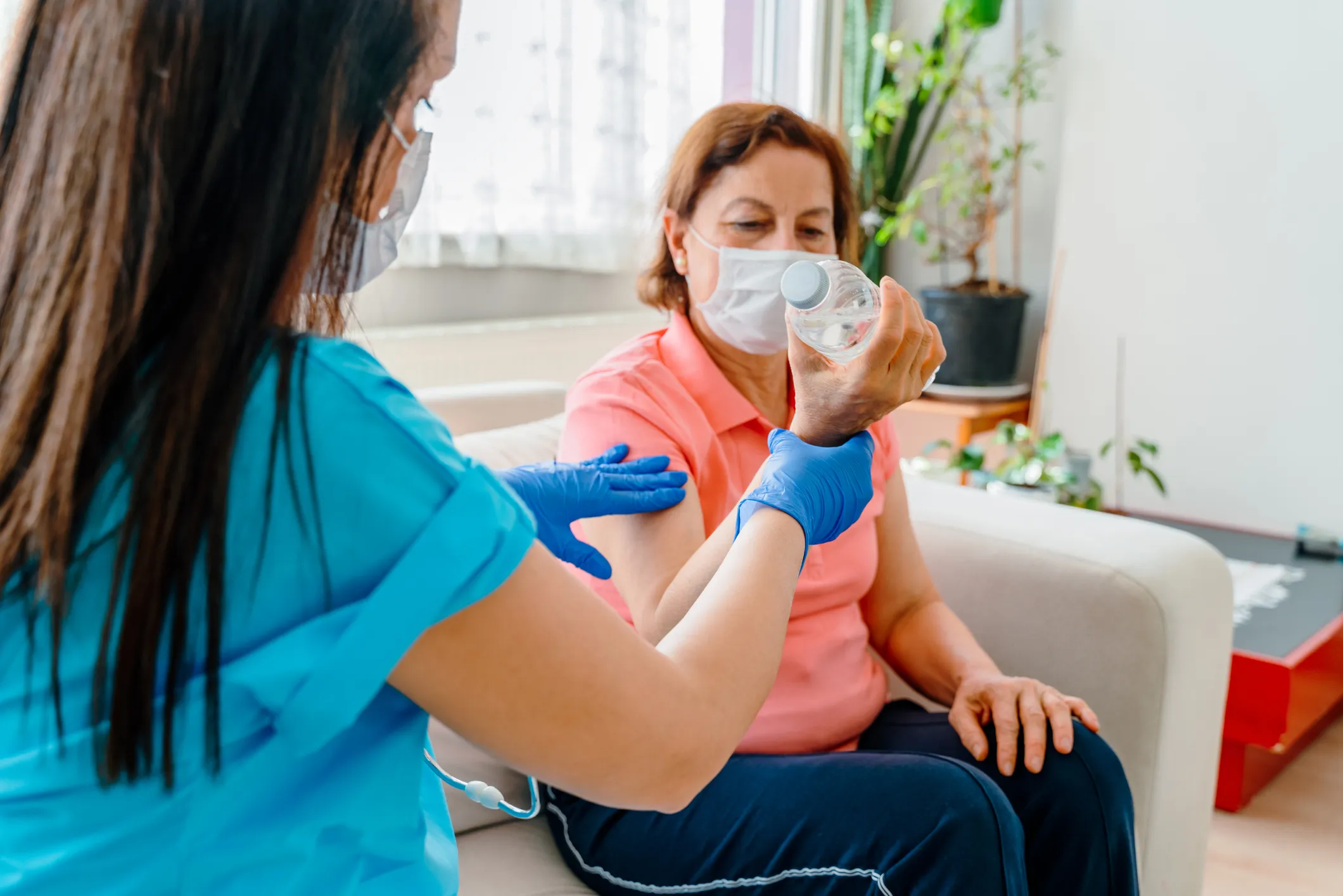 Therapist showing patient how to hold a water bottle