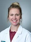 Jennifer Kosa, DO, smiles at the camera wearing her white coat
