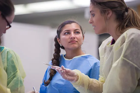 A surgical assisting student listens at Suture Fest 2016.
