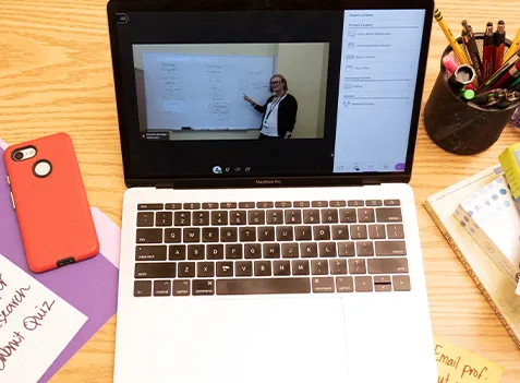A laptop showing a profession giving a lecture. 