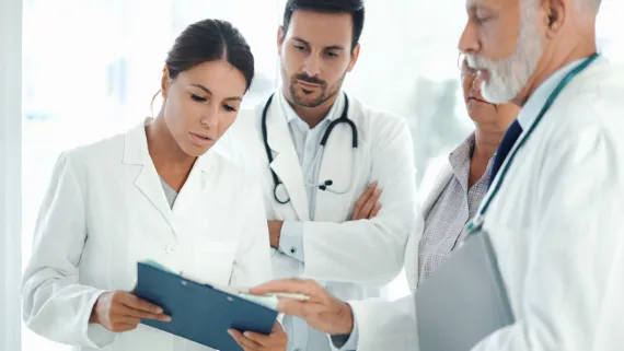 Female doctor discusses with two male doctors