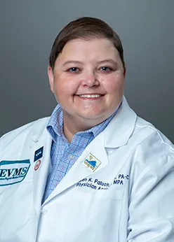Dr. Paluch smiles at the camera wearing her white medical coat