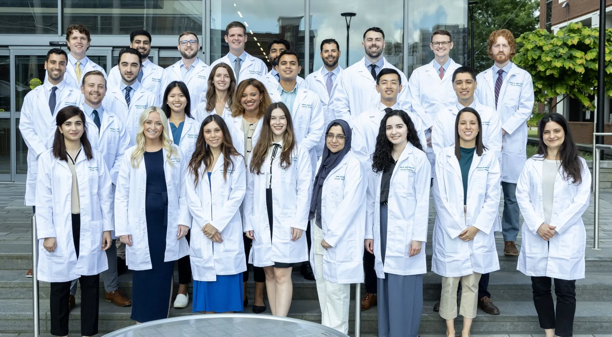 Residents in white coats face the camera