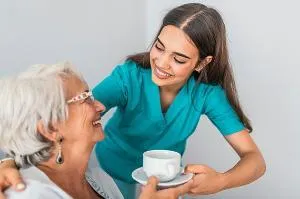 A fellow serves tea to a patient in hospice.
