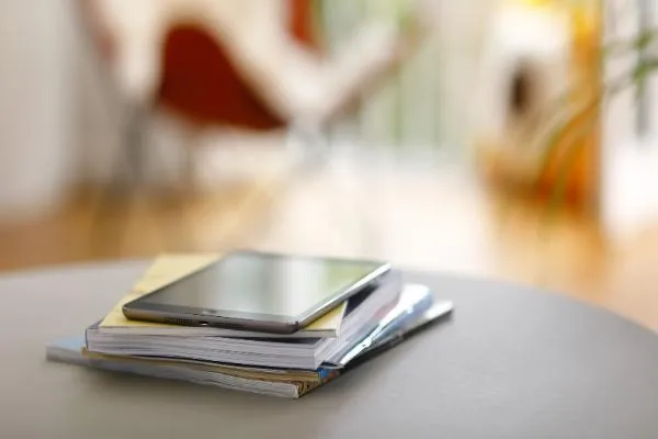 Tablet on top of stack of publications