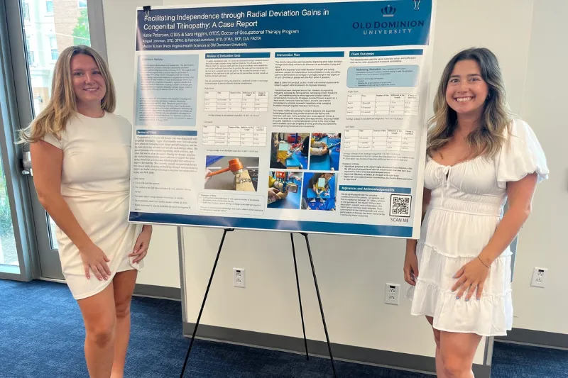 Two individuals stand with a poster detailing an occupational therapy case study