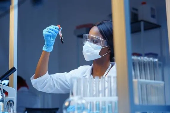 Profile of scientist facing DNA model