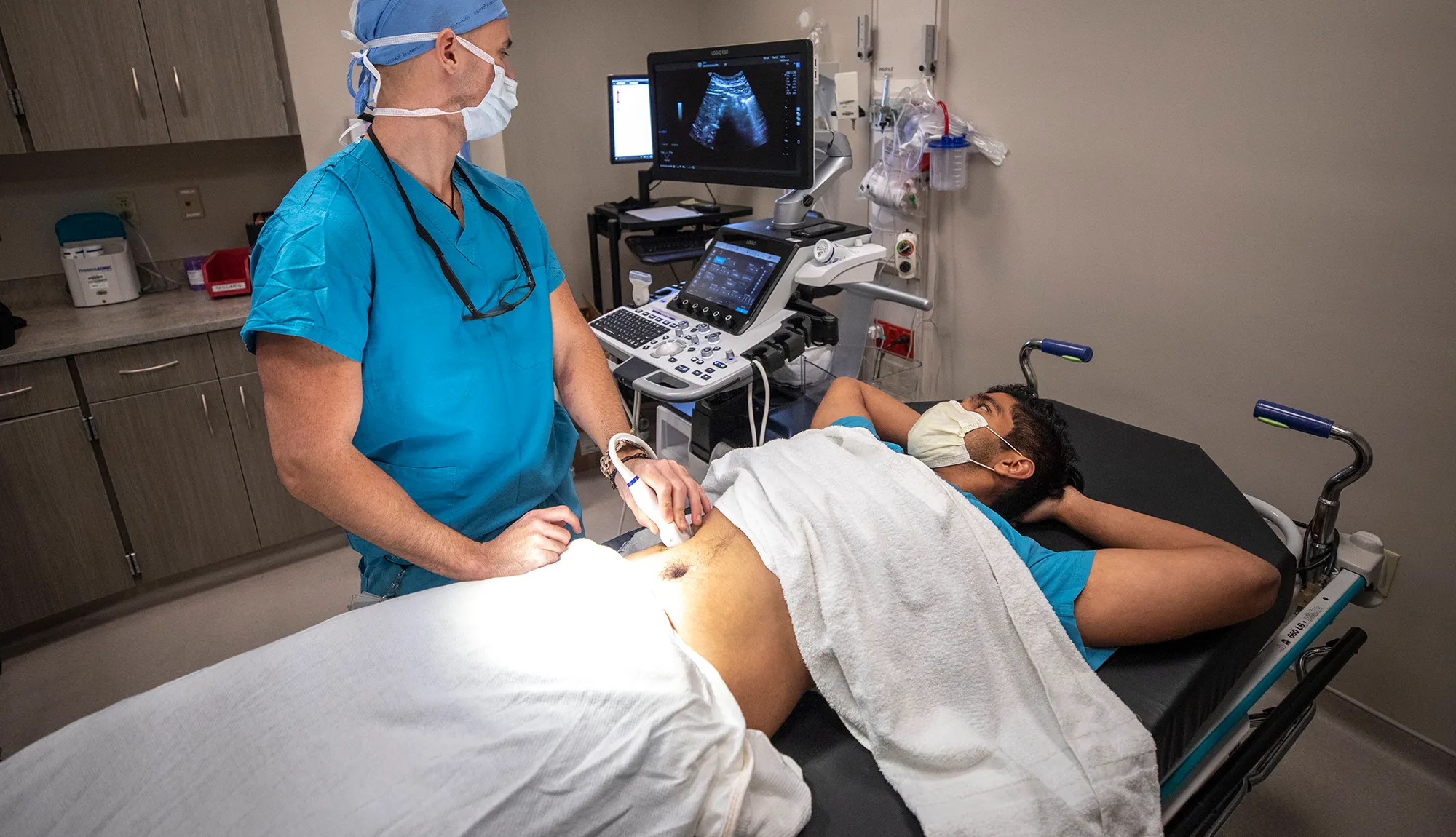 Radiologist performing ultrasound on a patient's abdomen