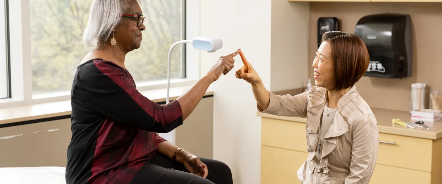 Dr. Kwon testing the motor skills of a patient by touching index fingers.