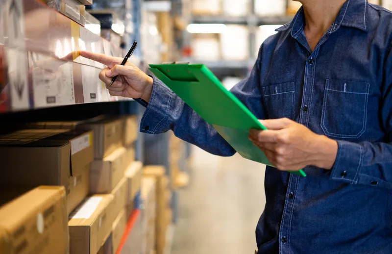 Worker in a warehouse with clipboard