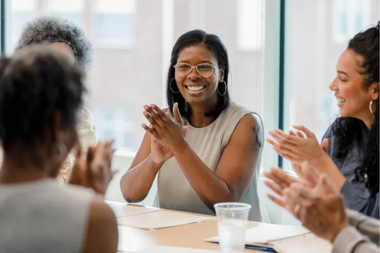 Smiling woman surrounded by colleagues in professional setting